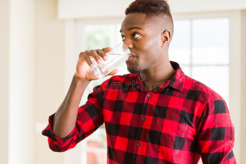 Young african american man drinking a fresh glass of water stock image
