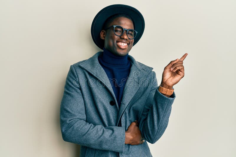 Young african american man wearing elegant style with a big smile on face, pointing with hand and finger to the side looking at the camera