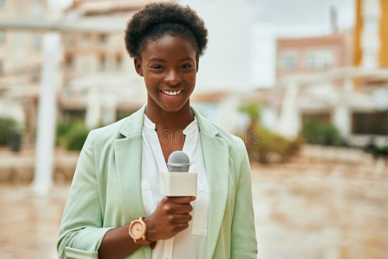 Young african american reporter woman using microphone at the city royalty free stock images
