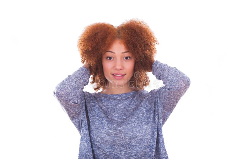 Young african american teenage girl holding her curly hair isol