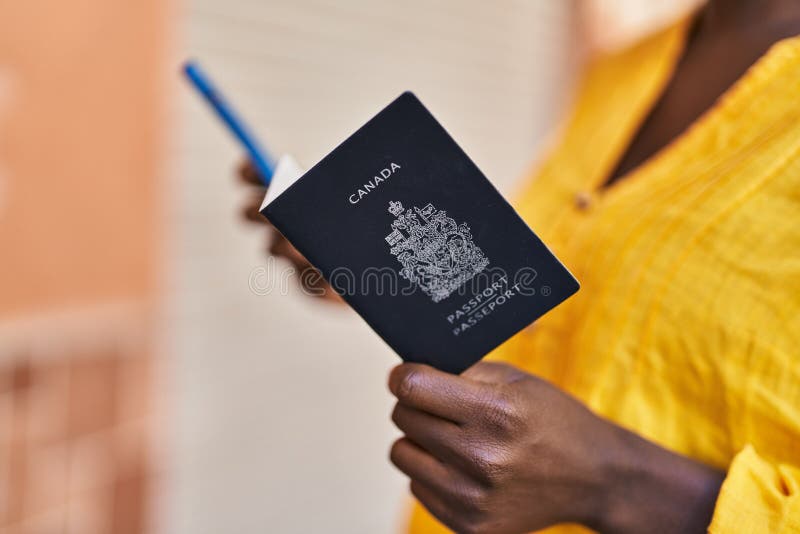 Young african american woman holding canada passport at street royalty free stock image