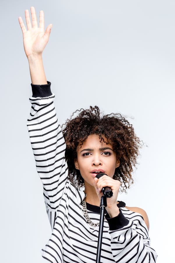 Young African American Woman Singing with Microphone Isolated on Grey ...