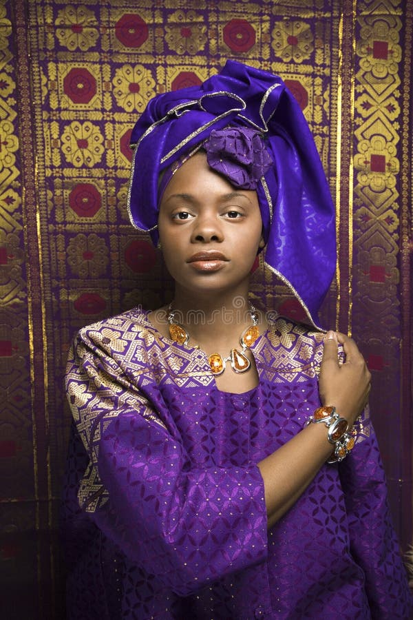 Portrét Africká Americká žena na sebe tradičné Africké oblečenie pred vzorované stenu.