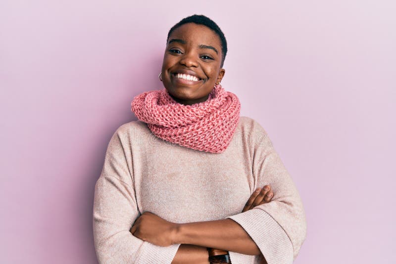 Young african american woman wearing winter scarf happy face smiling with crossed arms looking at the camera stock image