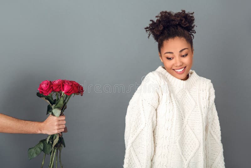 Young african woman isolated on grey wall studio winter concept shy