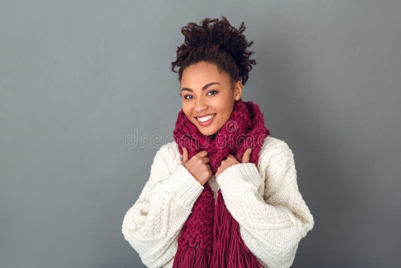 Young african woman isolated on grey wall studio winter concept wearing scarf