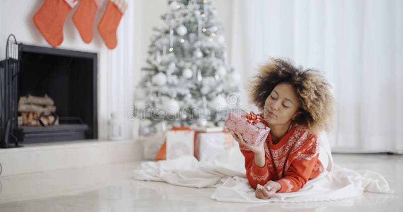 Young African girl lying looking at her Xmas gift