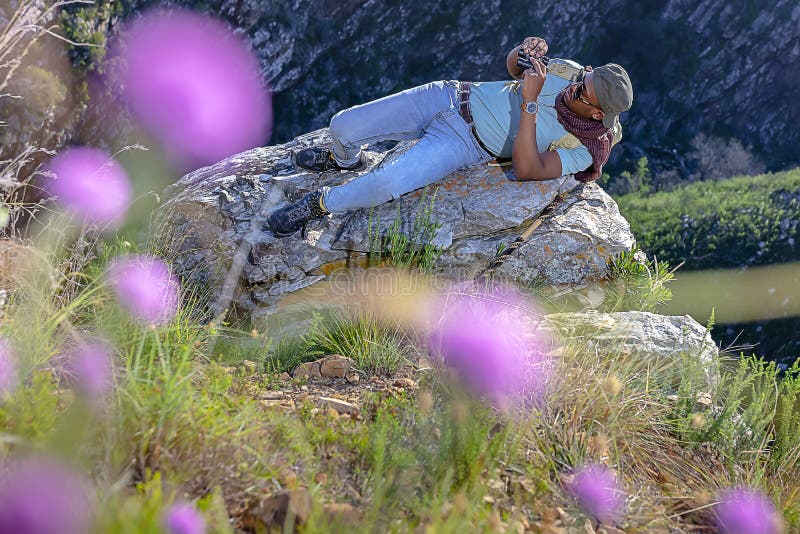 A young African male on the rocks during a hike in the mountains during spring time in South Africa