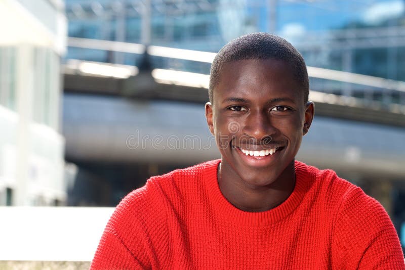 Young african man sitting outdoors and smiling royalty free stock images Young african man sitting outdoors and smiling royalty free stock images