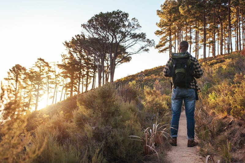Young African man standing on a trail in the afternoon stock image Young African man standing on a trail in the afternoon stock image