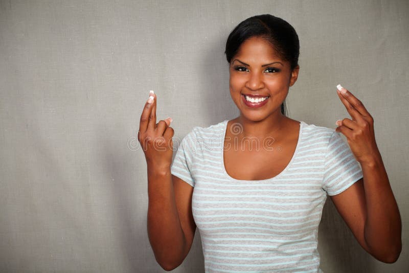 Young african woman crossing fingers while smiling stock photos Young african woman crossing fingers while smiling stock photos