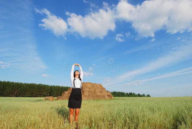 Young agronomist relaxation on a background of blue sky and hay bale