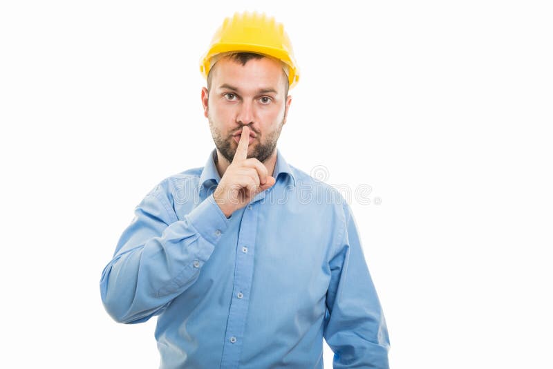 Young architect with yellow helmet showing silent gesture royalty free stock photo Young architect with yellow helmet showing silent gesture royalty free stock photo