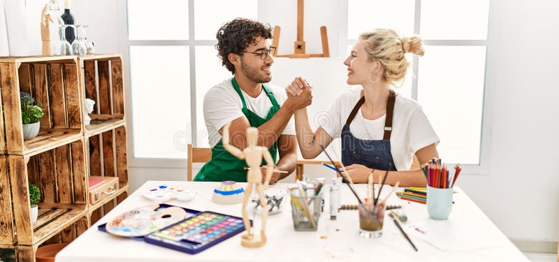 Young artist couple smiling happy shaking hands at art studio royalty free stock photo
