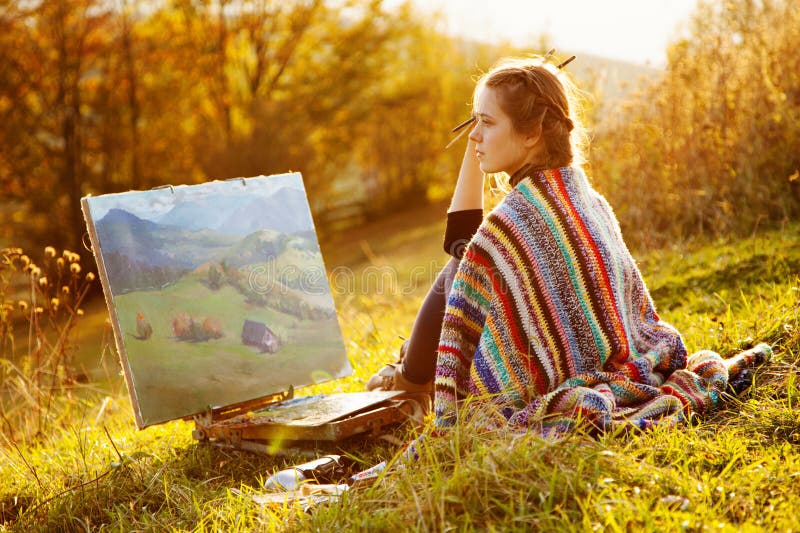 Young artist painting an autumn landscape