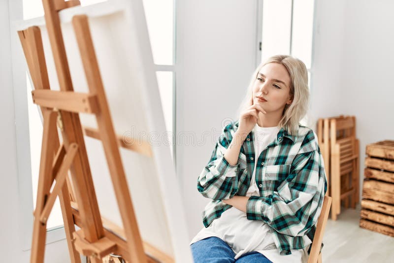 Young artist student girl concentrated looking canvas at art studio royalty free stock photography
