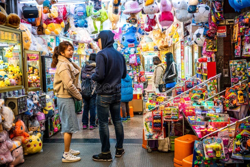 Young Asian adult couple on the porch of a colorful toys and games shop in Taipei Taiwan stock image Young Asian adult couple on the porch of a colorful toys and games shop in Taipei Taiwan stock image