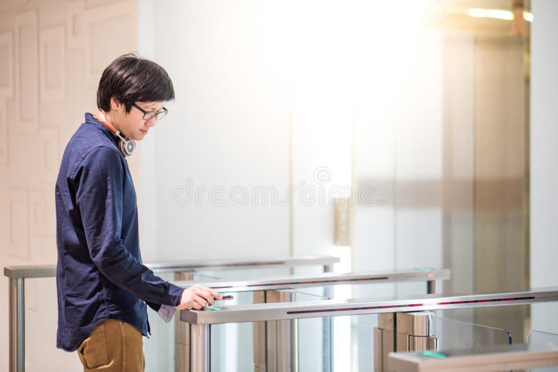 Young Asian Business Man Using Smartphone To Open Automatic Gate Stock