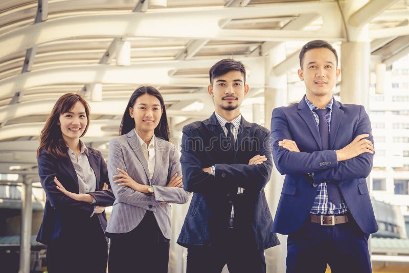 The young Asian business team stands with confidence and pride.
