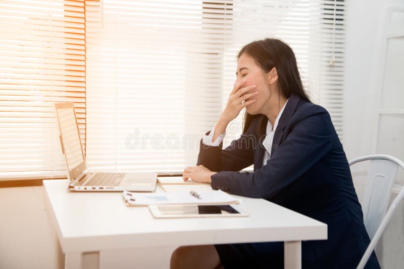 Young Asian business woman dozy on the desk in office because tired overworked. royalty free stock images Young Asian business woman dozy on the desk in office because tired overworked. royalty free stock images