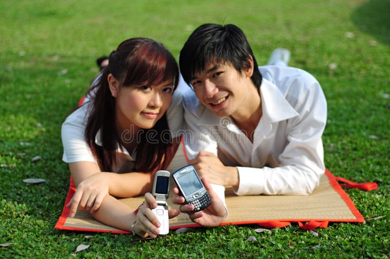 Young Asian Couple with phone in park 2