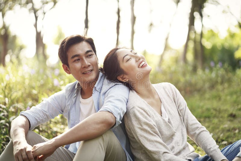 Young asian couple relaxing in park