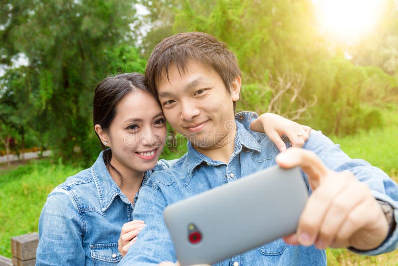Young asian couple take selfie in park royalty free stock photos Young asian couple take selfie in park royalty free stock photos