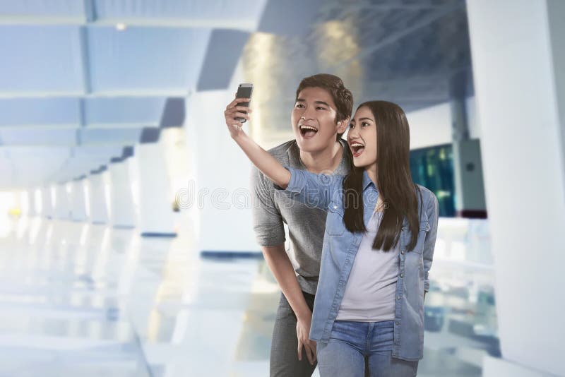 Young asian couple taking selfie by smartphone stock photo Young asian couple taking selfie by smartphone stock photo
