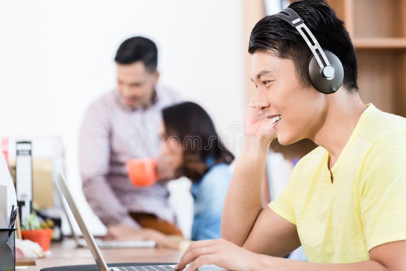 Young Asian employee watching a video presentation on laptop in stock images Young Asian employee watching a video presentation on laptop in stock images