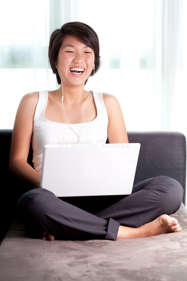 Young Asian executive laughs while chatting online