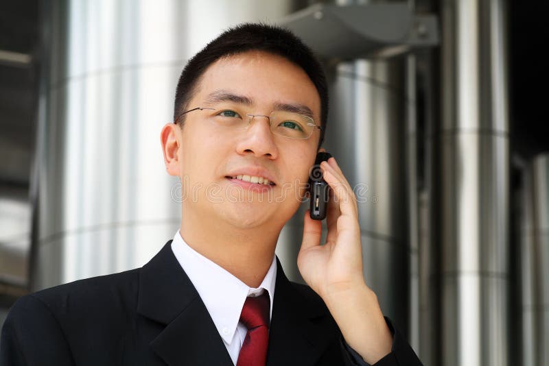 Young asian executive talking on handphone royalty free stock photography