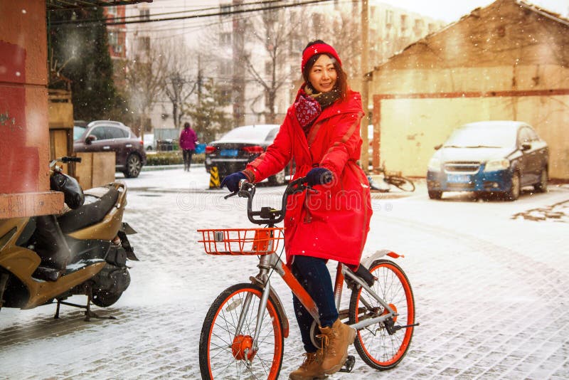 Young Asian girl on a bike in winter in the yard. royalty free stock photo Young Asian girl on a bike in winter in the yard. royalty free stock photo