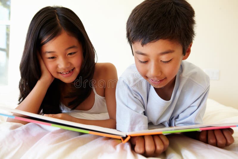 Young Asian girl and boy reading book