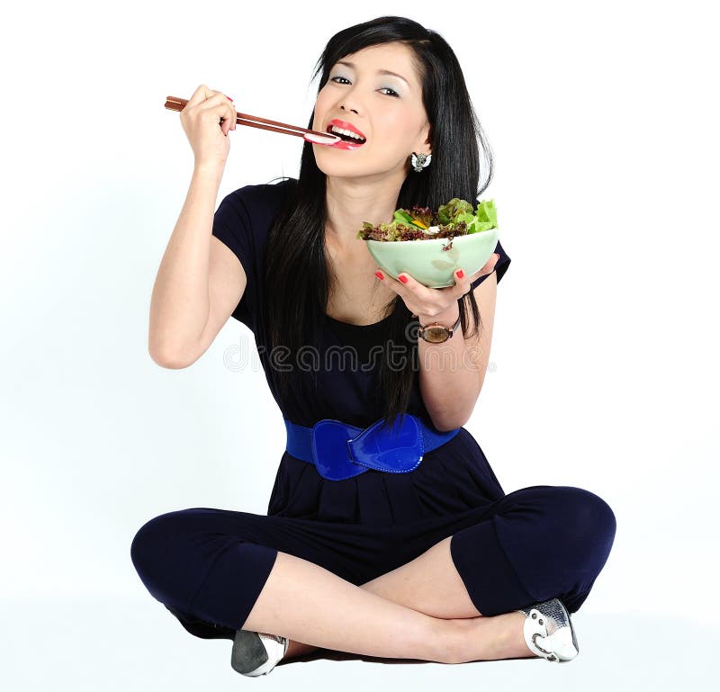 Young asian girl eating salad