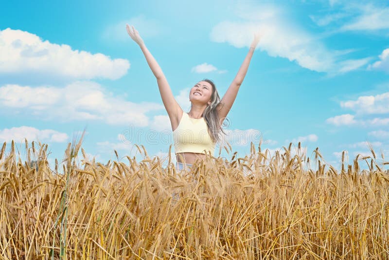 Young Asian Girl Smiling Walks through a Wheat Field Throwing Up Her ...