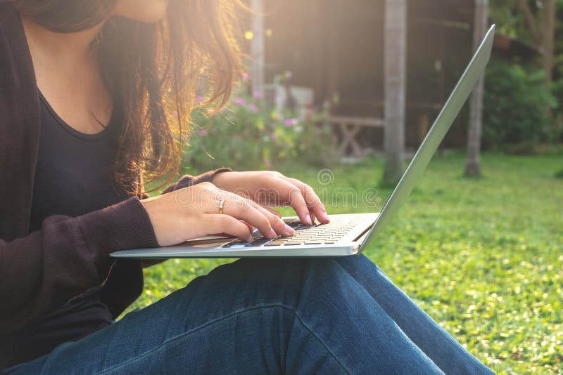 Young asian girl using laptop at a outdoors stock image Young asian girl using laptop at a outdoors stock image