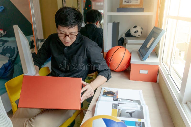 Asian man opening box sitting in bedroom royalty free stock photos Asian man opening box sitting in bedroom royalty free stock photos