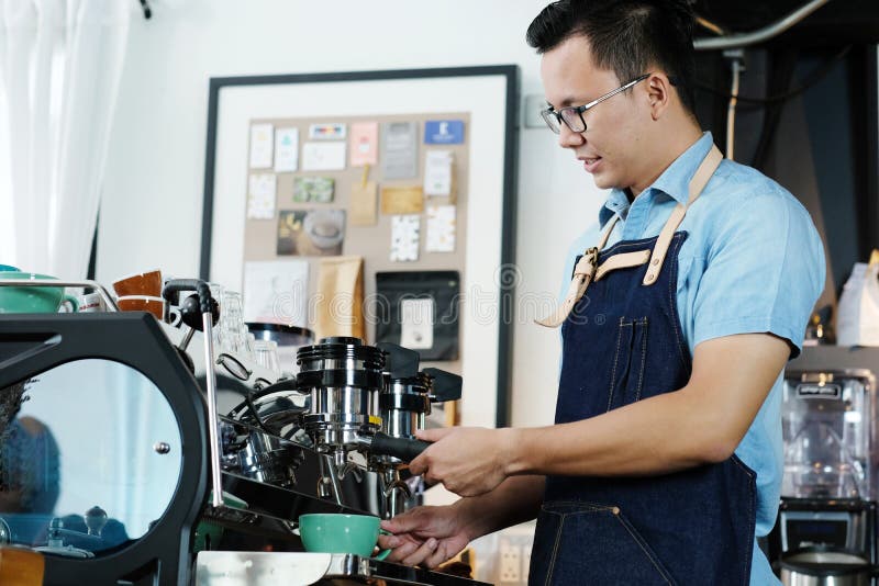 Young asian man barista making a cooffe cup at counter cafe back royalty free stock photography Young asian man barista making a cooffe cup at counter cafe back royalty free stock photography