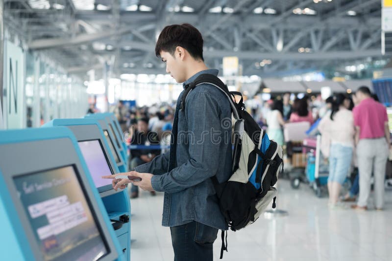 Young asian man using self check-in kiosks in airport stock photos