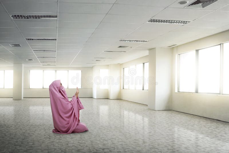 Young asian muslim woman wearing niqab praying to god