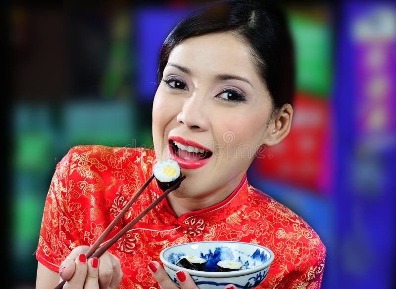 Young asian woman eating sushi