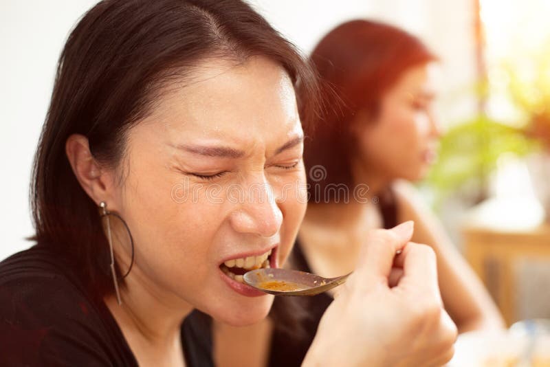 Young Asian Woman eats spicy hot tomyum noodle soup and hanging on spoon to mouth with sweat delicious enjoy eating. Young Asian Woman eats spicy hot tomyum noodle soup and hanging on spoon to mouth with sweat delicious enjoy eating