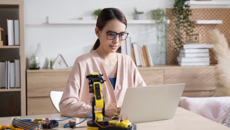 Young Asian woman engineer programer working on robotics project at home. stock photography