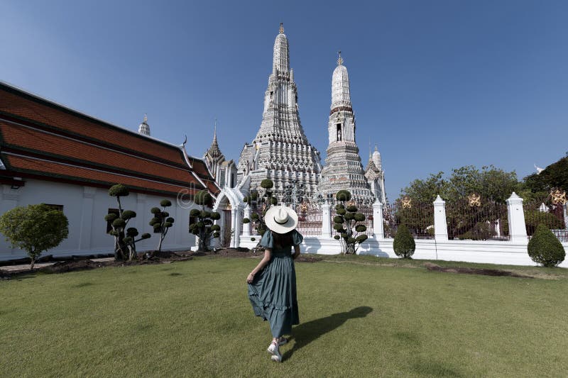 Young Asian woman is enjoy sightseeing and traveling at Wat Arun temple in Bangkok