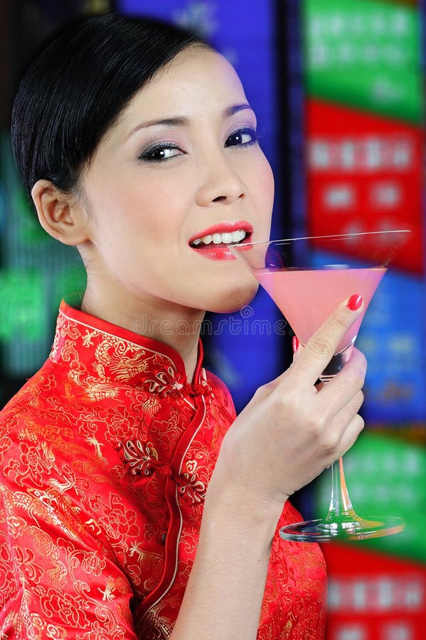 Young asian woman holding a glass of cocktail