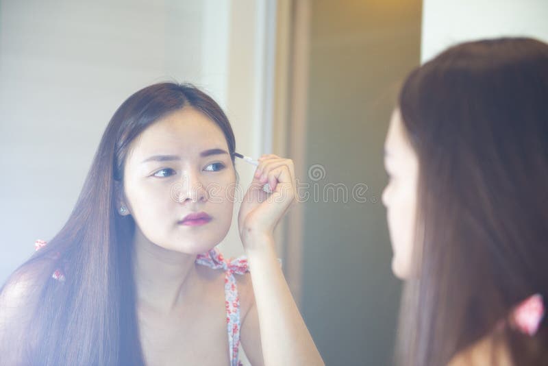 Young Asian woman is making up her face stock images Young Asian woman is making up her face stock images