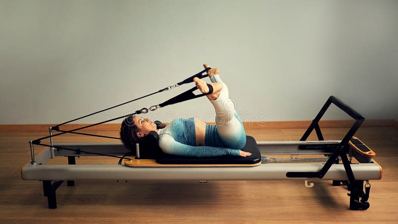 Young asian woman pilates stretching sport in reformer bed instructor girl in a studio stock photography Young asian woman pilates stretching sport in reformer bed instructor girl in a studio stock photography