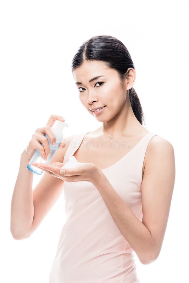 Young beautiful Asian woman pouring on hand cosmetic foam for skin care. Young beautiful Asian woman pouring on hand cosmetic foam for skin care