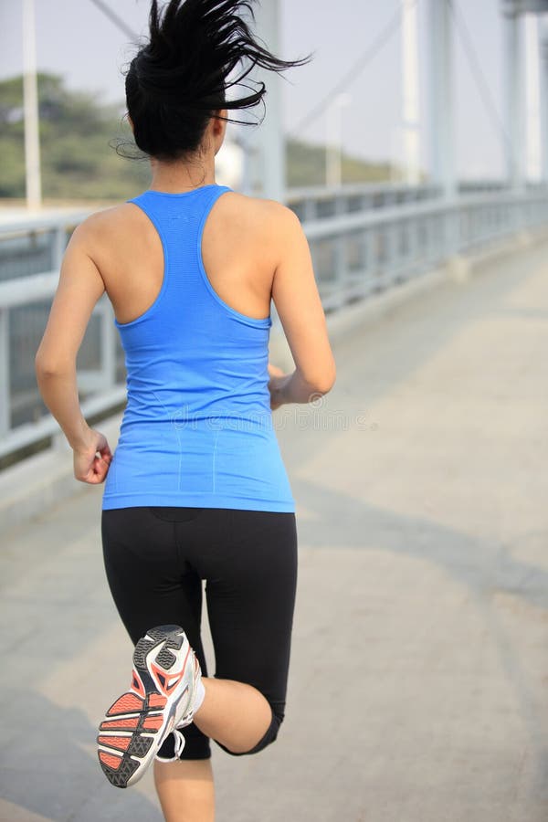 Young asian woman running at modern city footbridg stock photo Young asian woman running at modern city footbridg stock photo