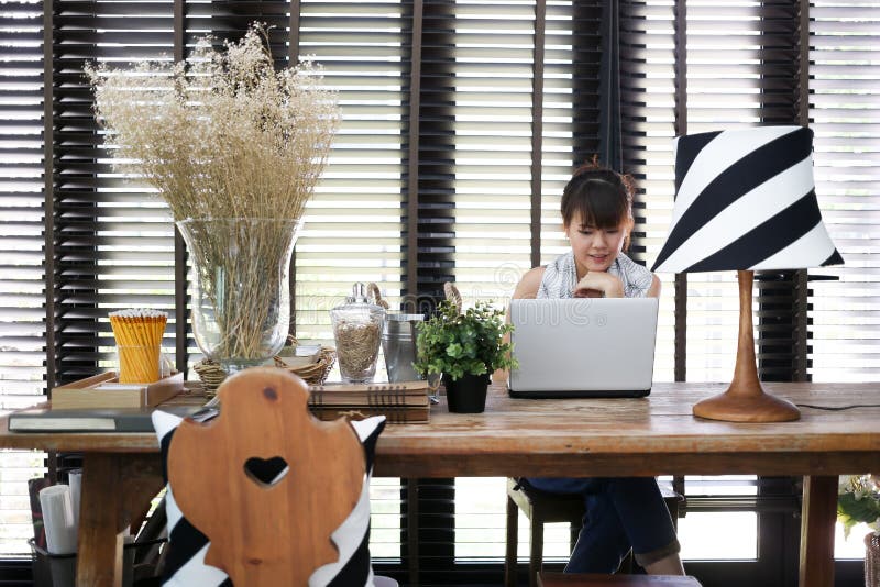 Young asian working woman is using a laptop with vintage decoration royalty free stock photos Young asian working woman is using a laptop with vintage decoration royalty free stock photos